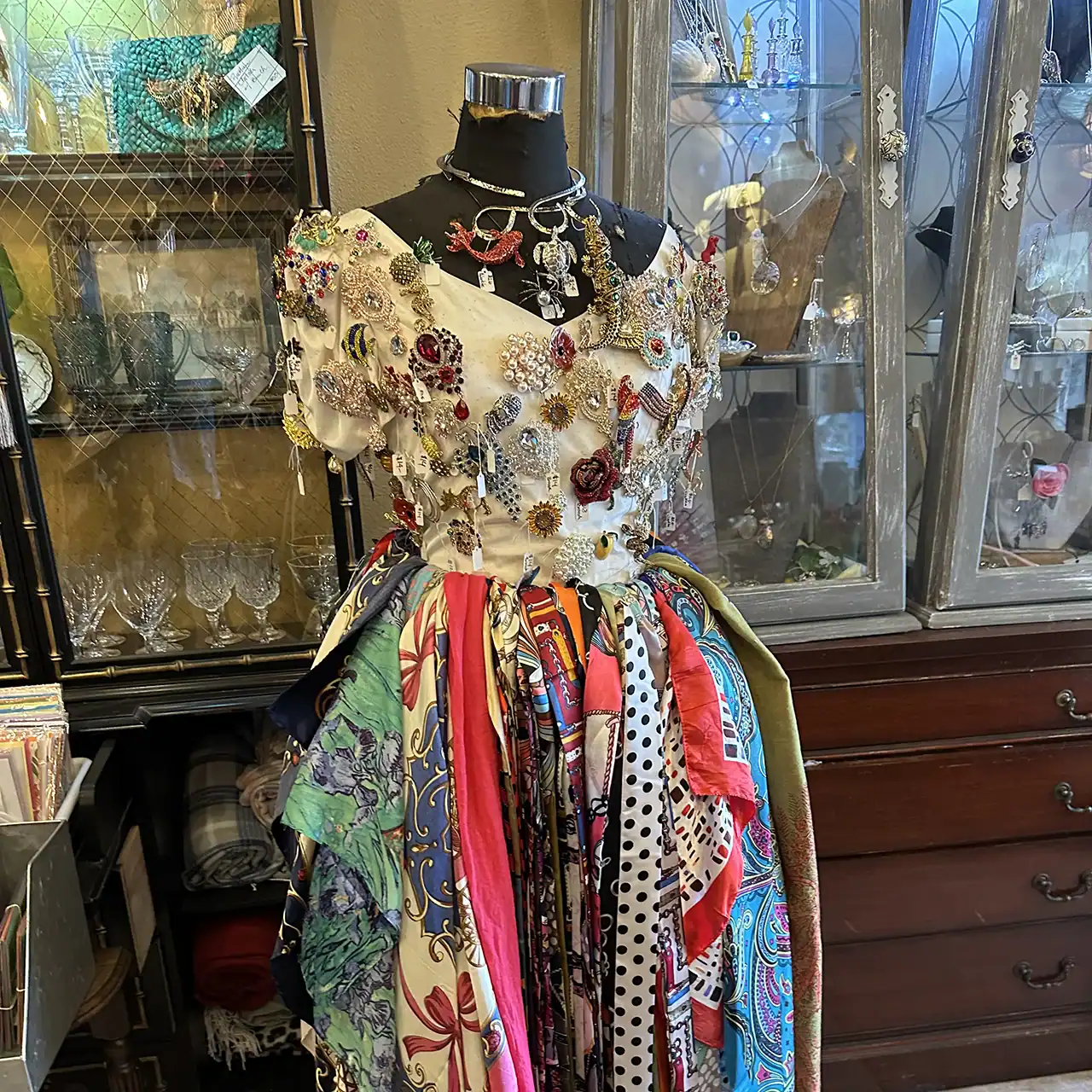 Mannequin dressed in a floral embroidered blouse and vibrant patchwork skirt.