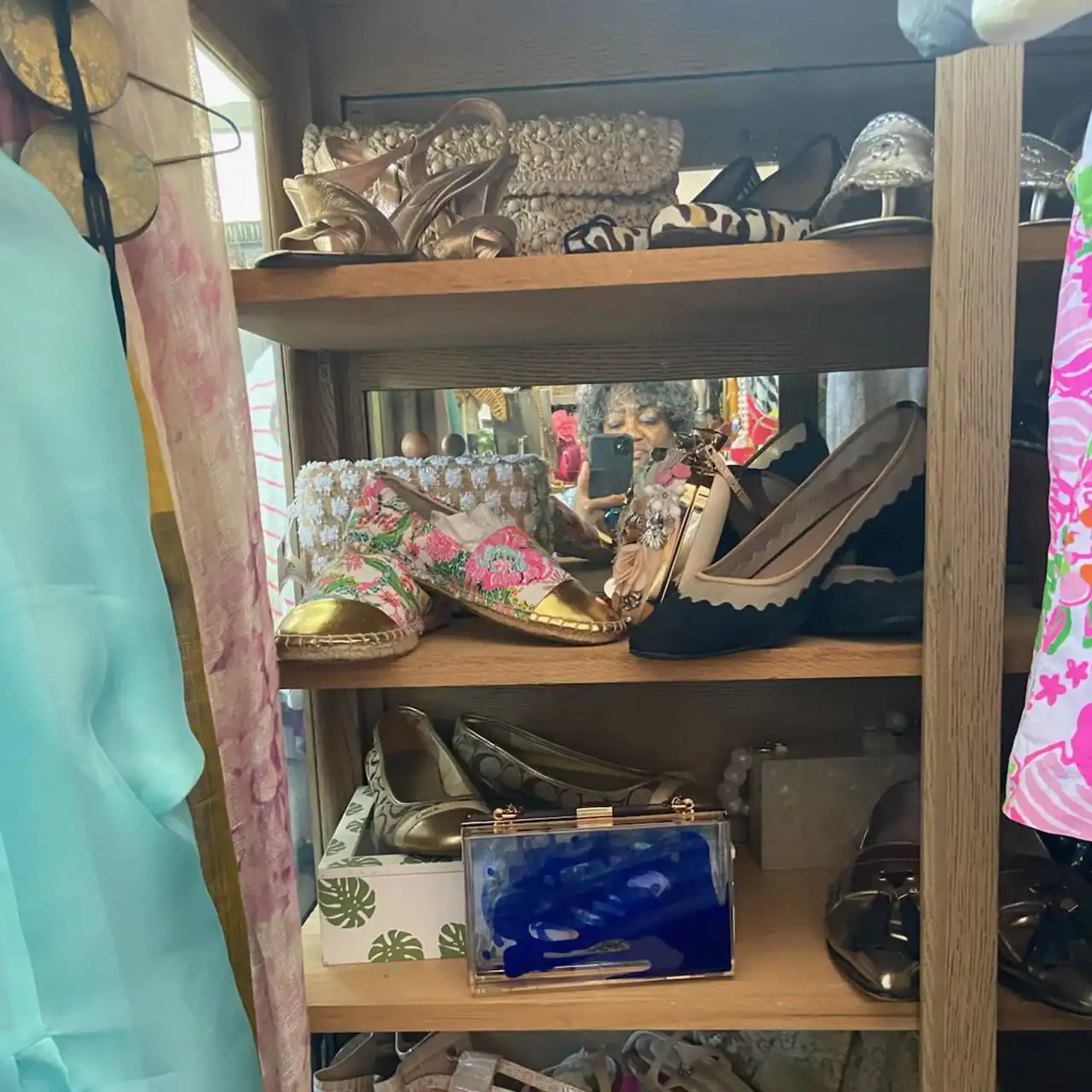 Shoe display shelf showcasing an assortment of shoes, including heels, flats, and sandals, in a reta.