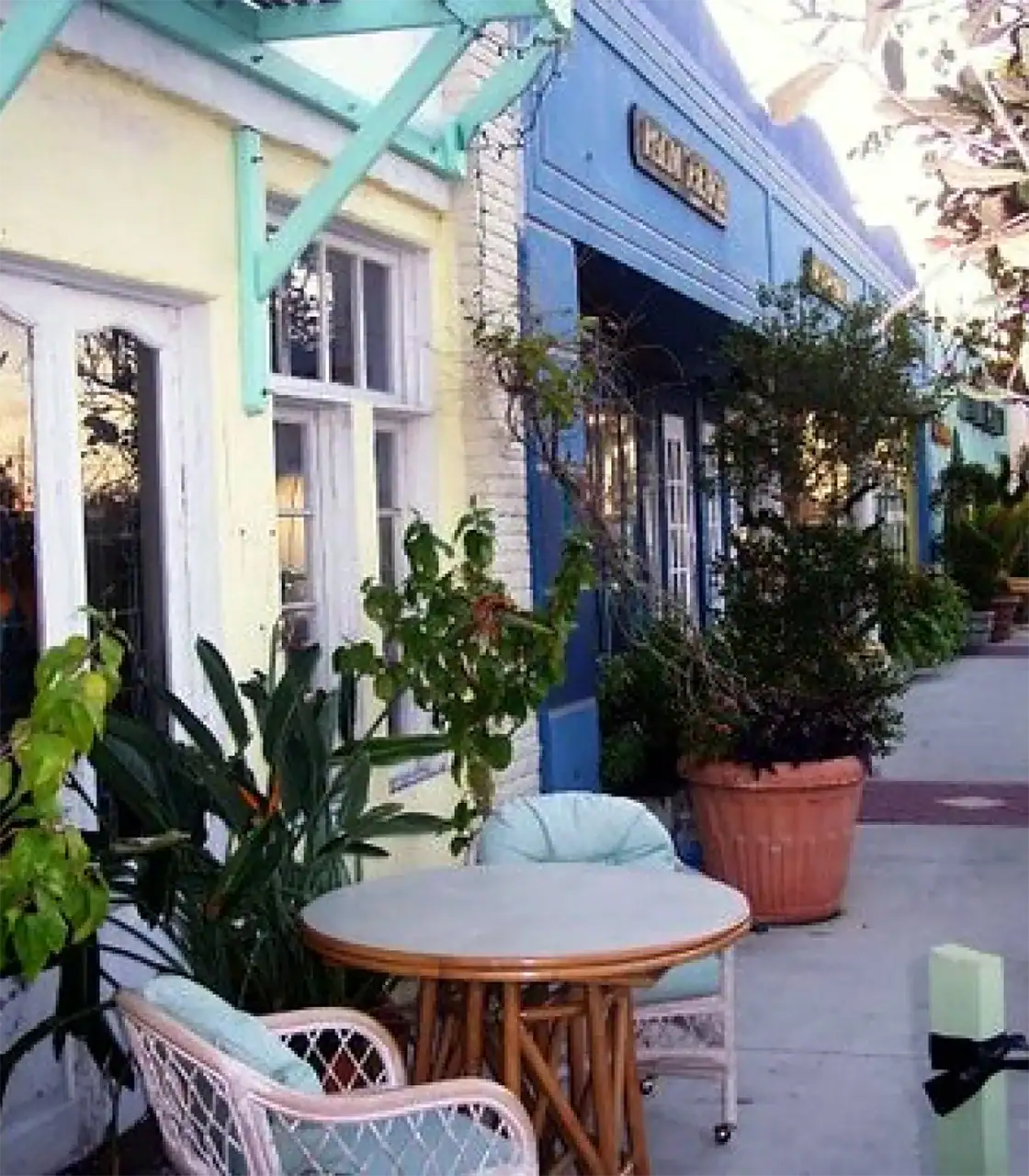 Outdoor seating area with a round table and cushioned chairs in front of a vibrant building.