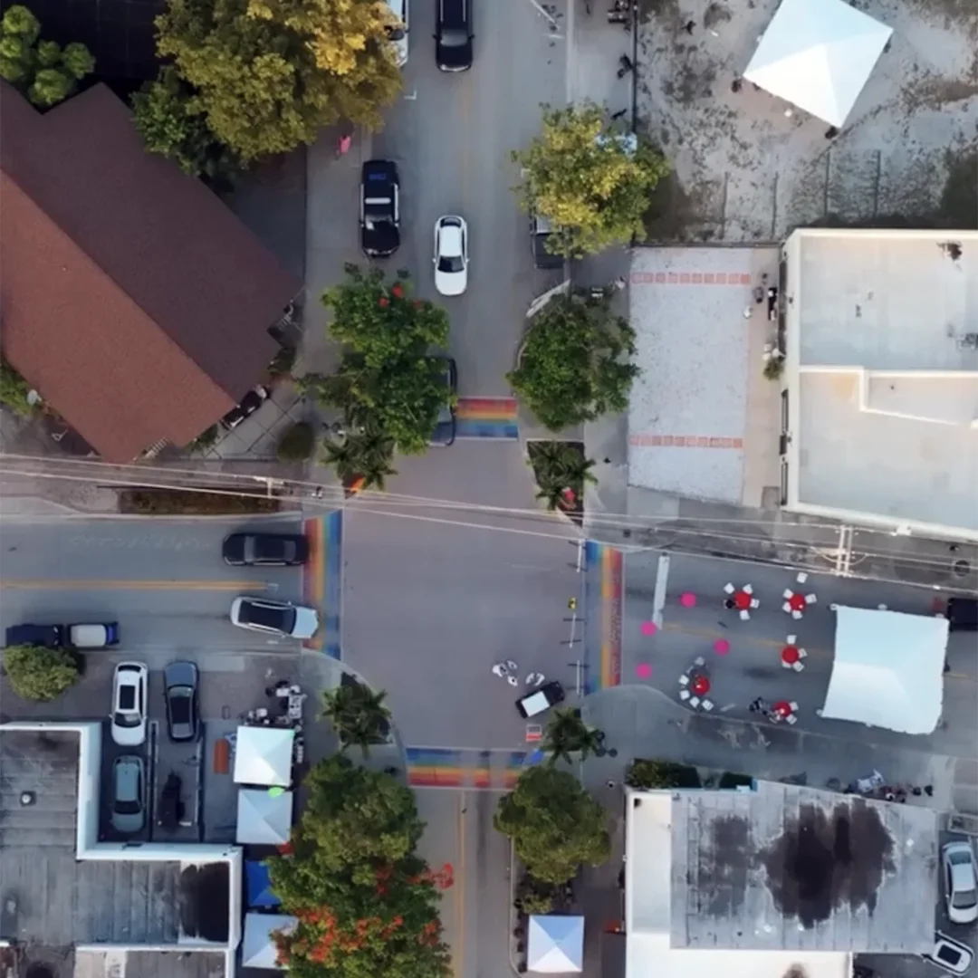 Colorful crosswalks and trees on a city street from aerial view.