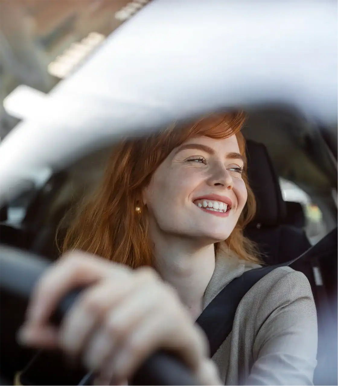 Woman smiling while driving a car.