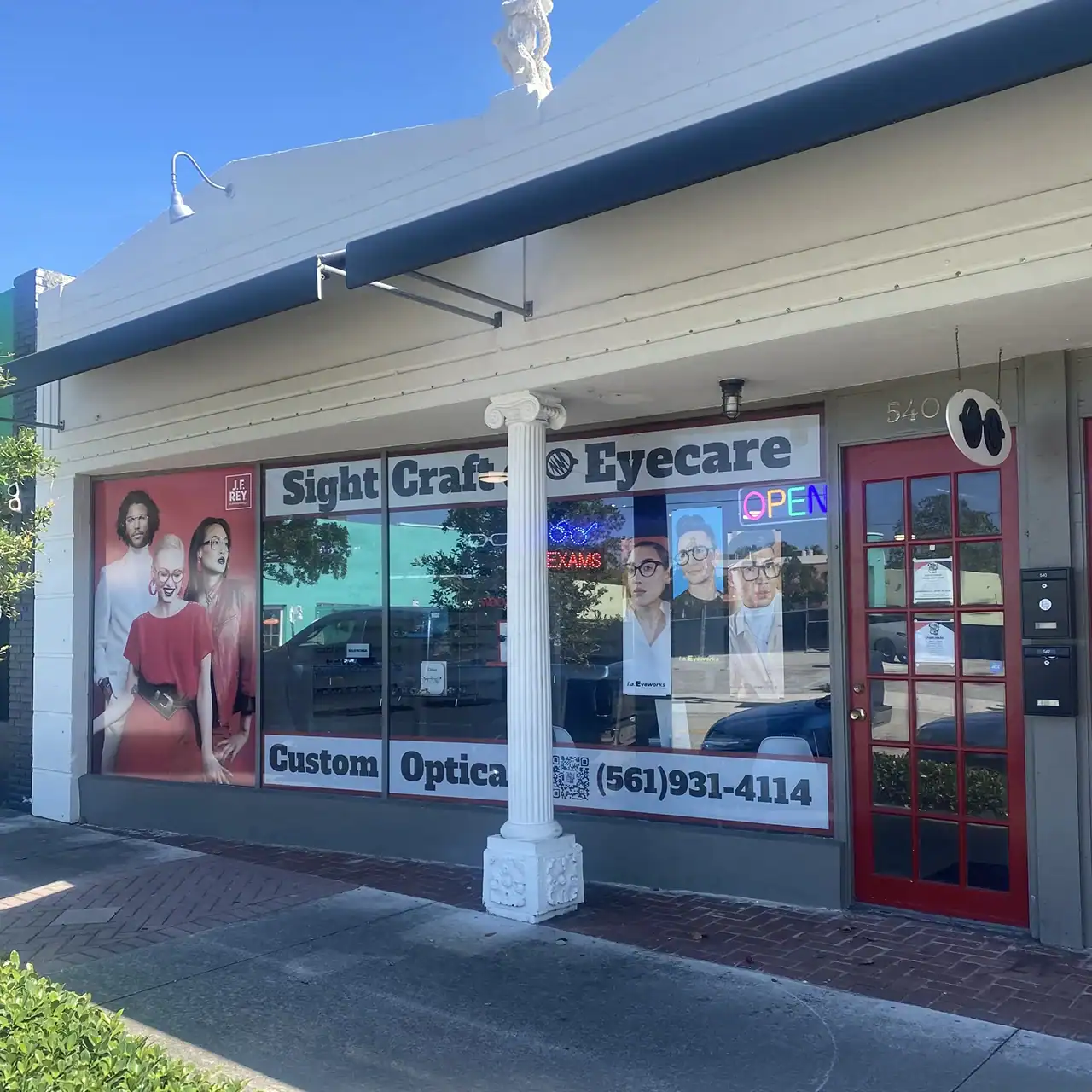 Eyecare clinic with large window displays and "OPEN" sign.